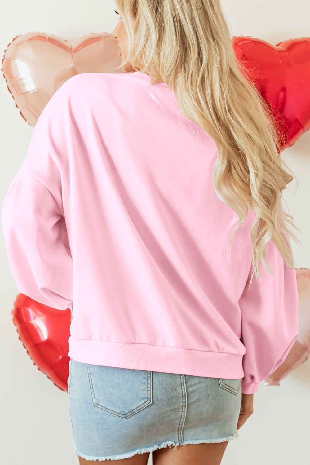 Women's blush pink pullover with chic bow accents