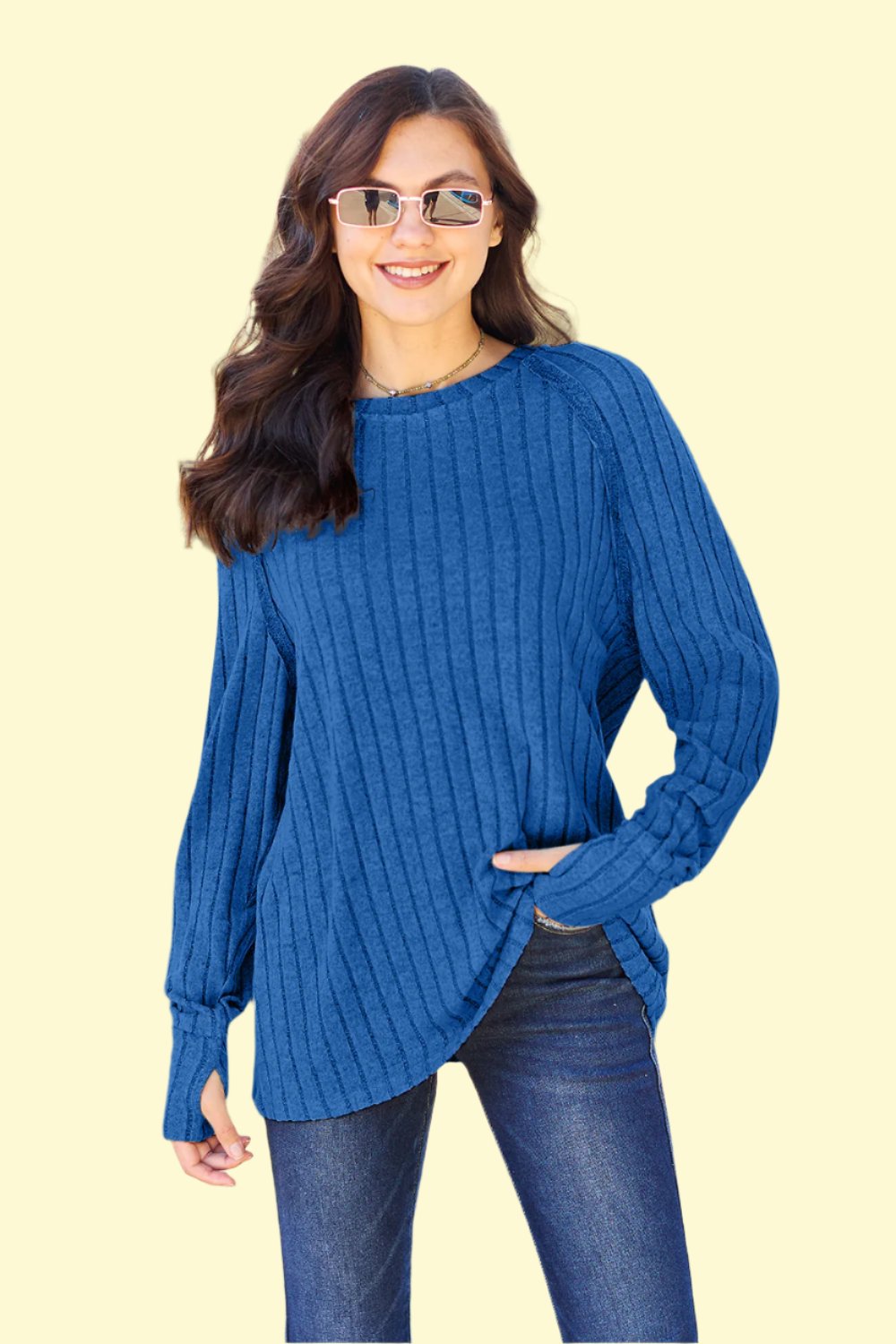 Model posing in a royal blue ribbed knit top