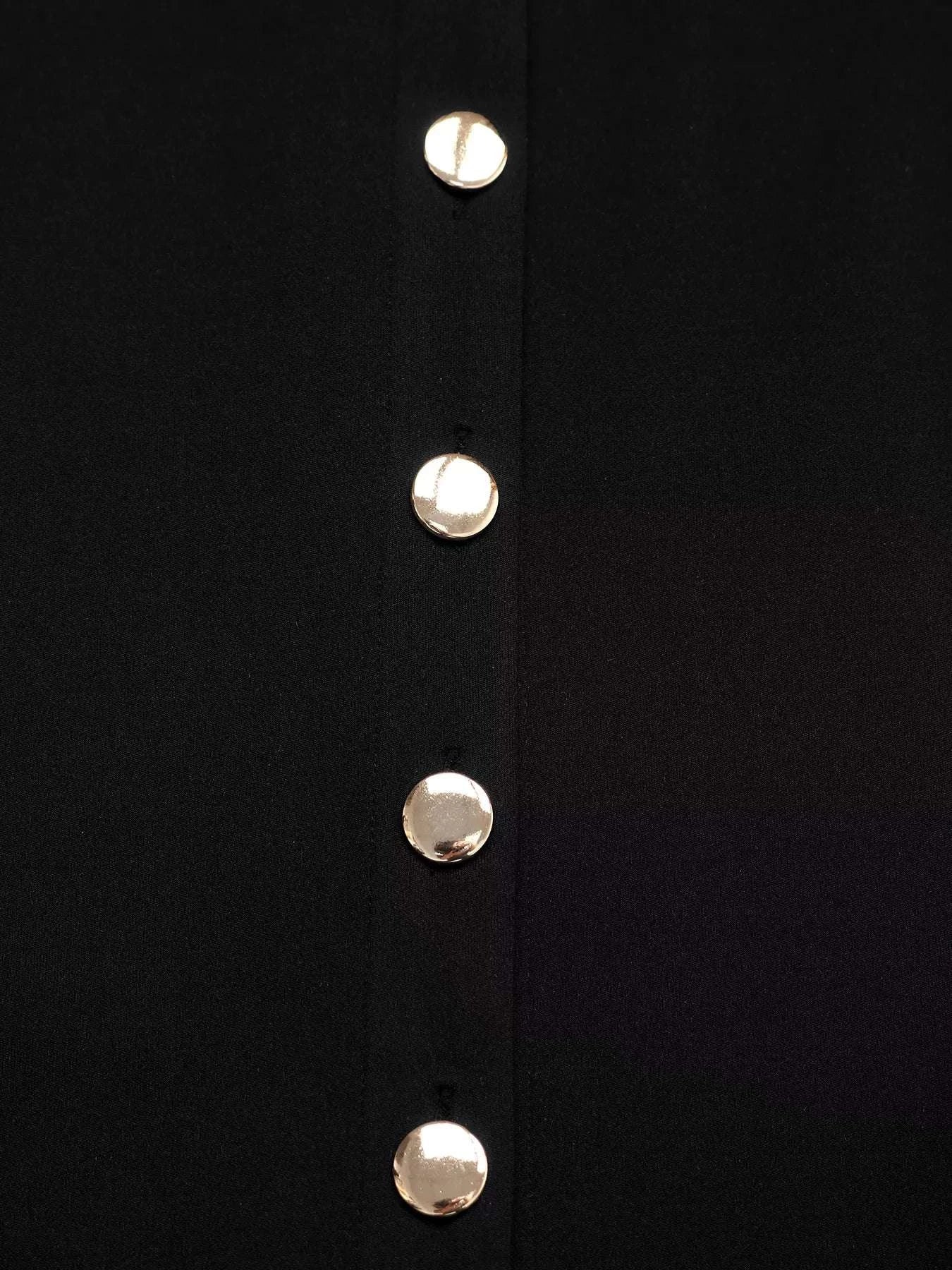 Close-up of a black garment with gold buttons on a white background