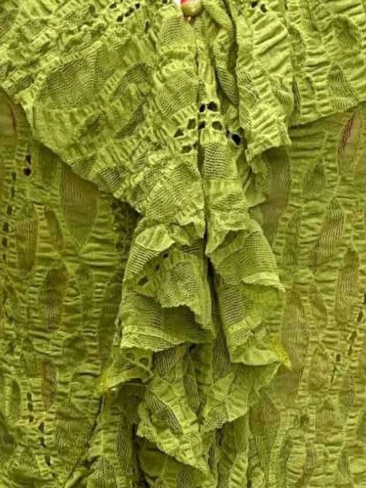 Close-up of lace detailing on women’s lime blouse